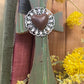 olive green cross with white metal floral accent and copper heart