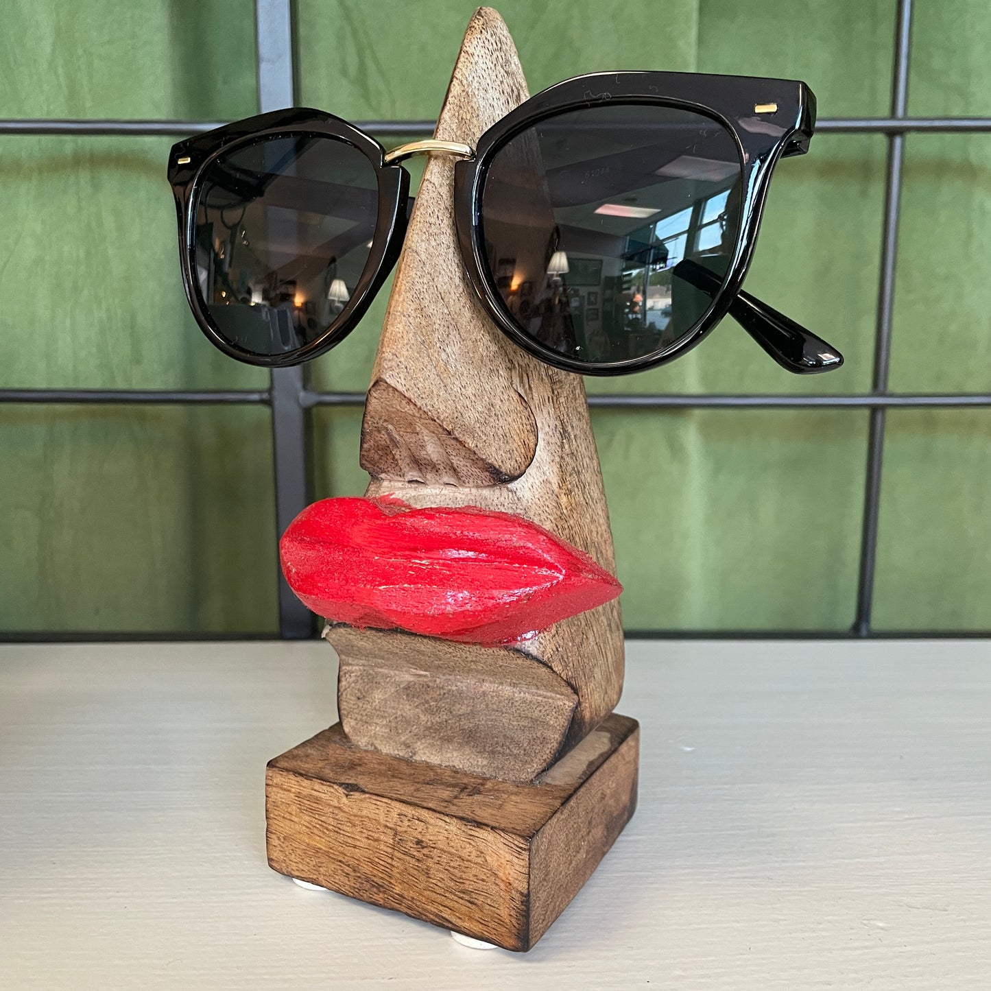 wooden eyeglass display replicating a face when glasses are worn