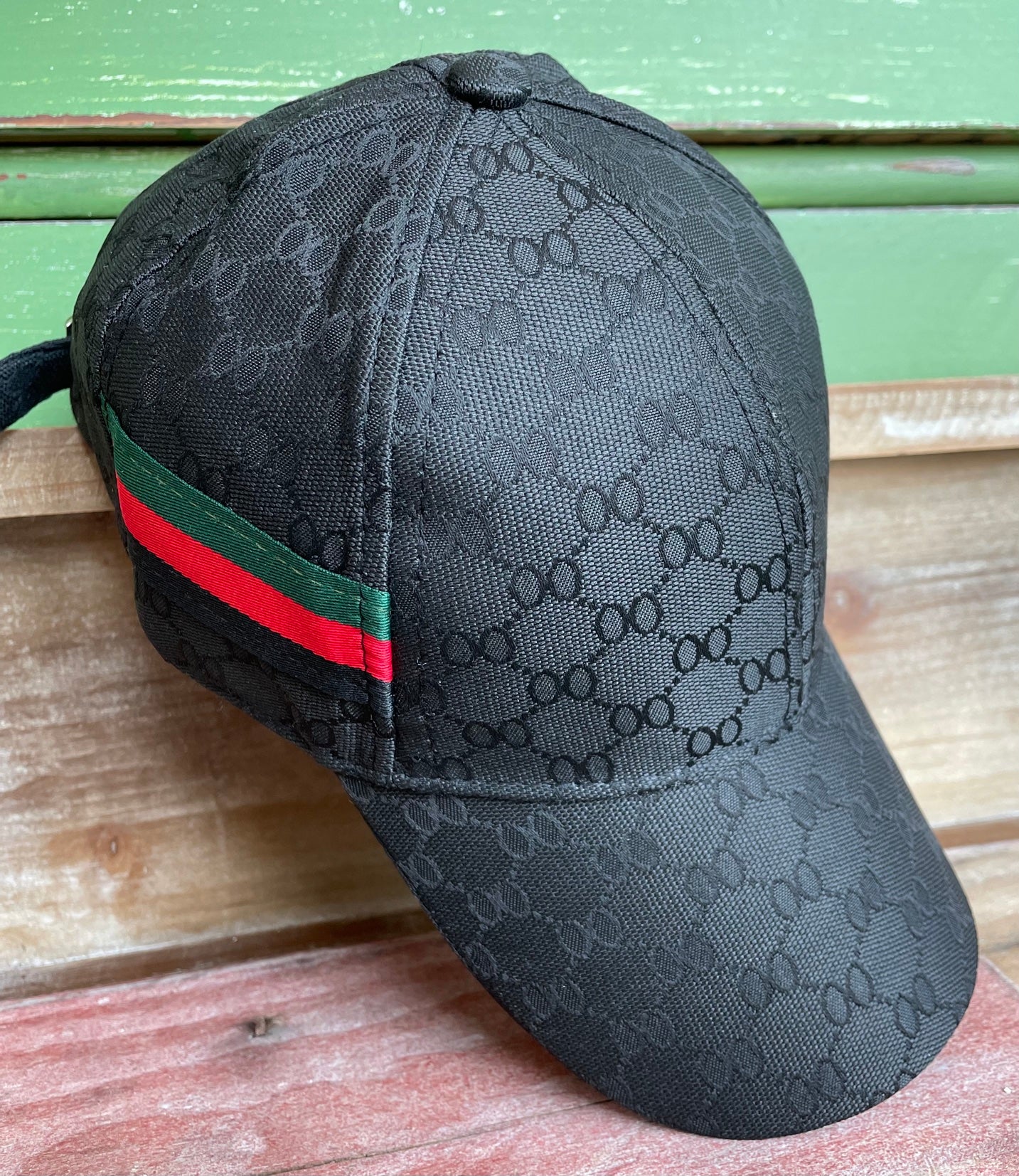 honeycomb print black hat with green, red and black stripe on side