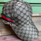 honeycomb print brown hat with green, red and black stripe on side