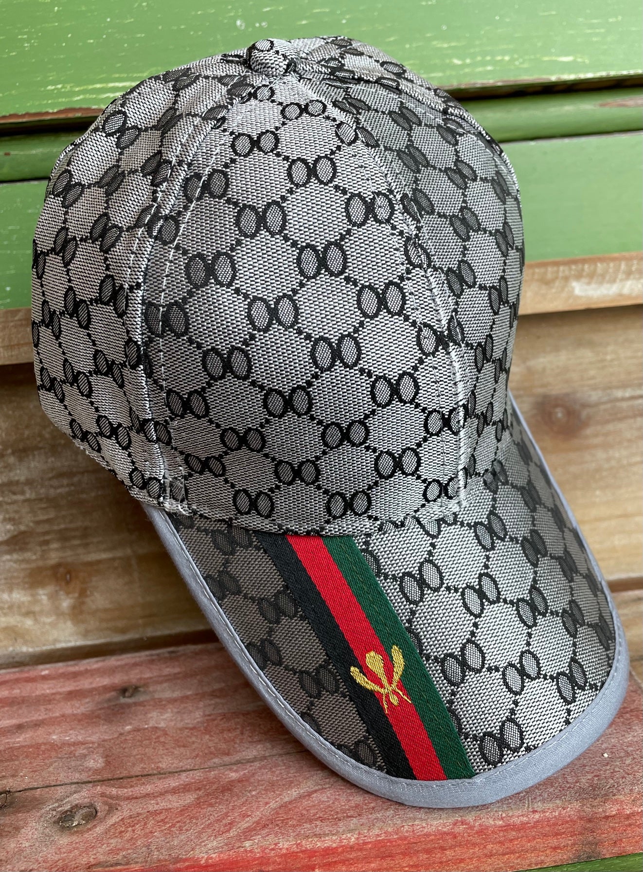 designer inspired grey hat with black, red and green stripe on bill with bumblebee