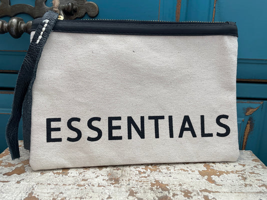 "essentials" white canvas zippered pouch with black writing